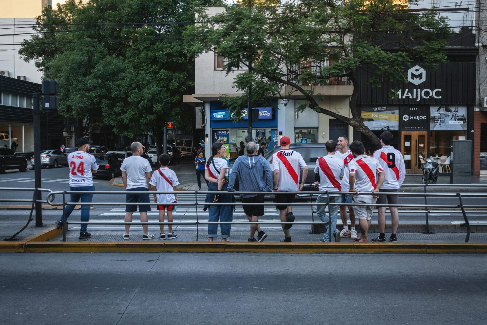 Fans of River Plate football club gather on a Buenos Aires street, showcasing team spirit and camaraderie.